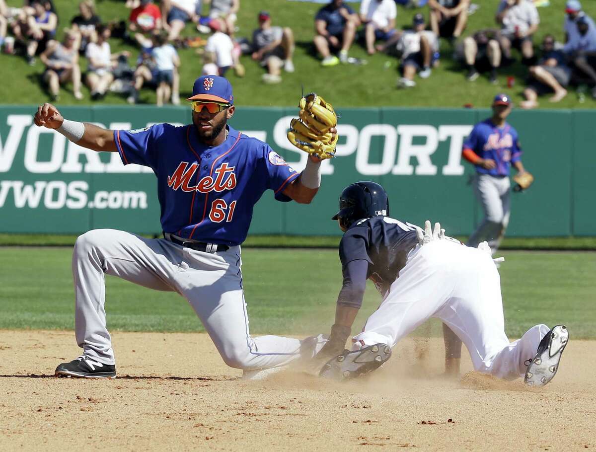 New York Mets shortstop Amed Rosario (61) looks to the umpire for a ruling after Atlanta Braves’ Travis Demeritte, right, stole second base in the fifth inning of a spring training baseball game, Friday in Kissimmee, Fla.