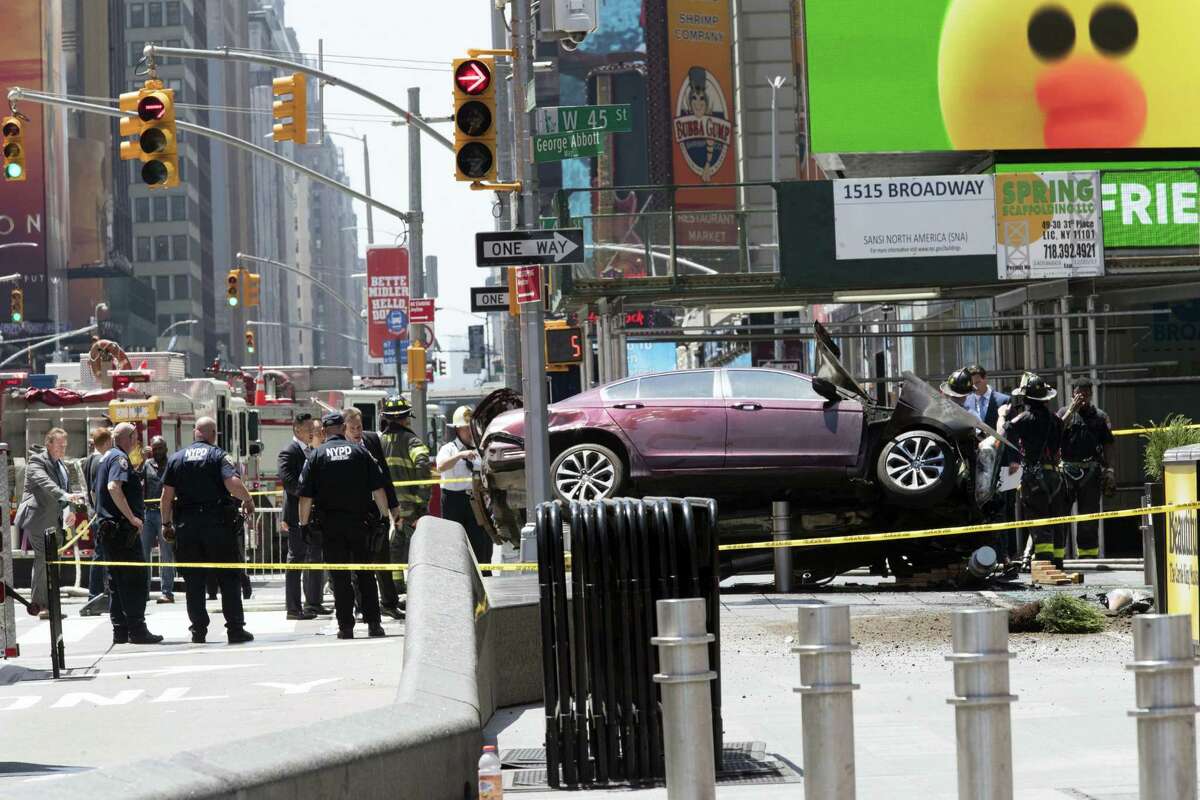 A car rests on a security barrier in New York’s Times Square after driving through a crowd of pedestrians, injuring at least a dozen people, Thursday, May 18, 2017.