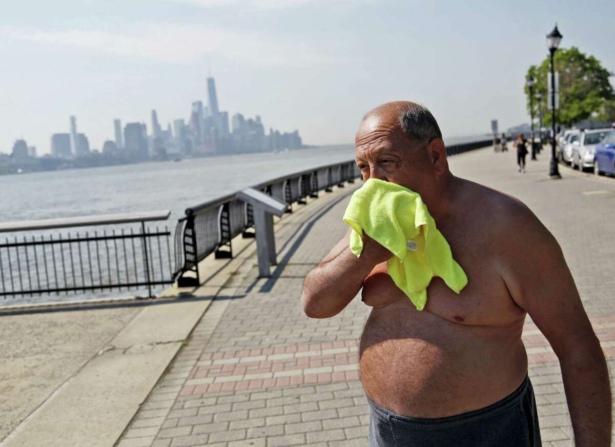Ed Tirone takes a break from reading on the pier to wipe a wet washcloth over his face in Hoboken, N.J., Thursday, May 18, 2017. Forecasters say temperatures across the state could reach the above 90 degrees on Thursday and the trend is expected to continue through Friday.