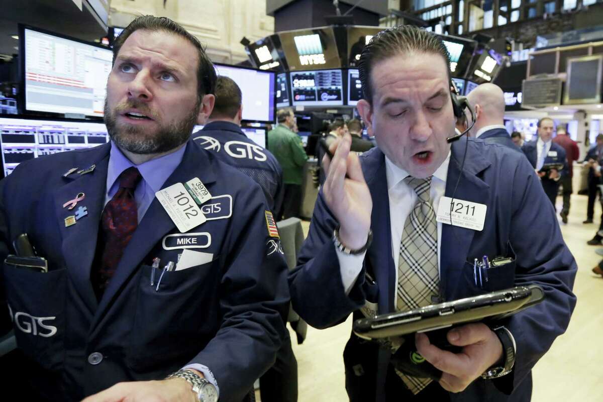 Specialist Michael Pistillo, left, and trader Tommy Kalikas work on the floor of the New York Stock Exchange Monday.