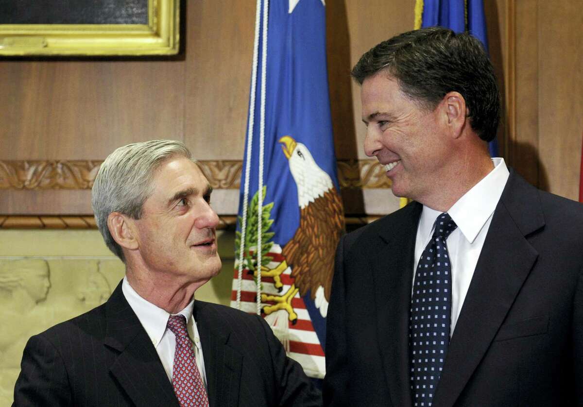 In this Sept. 4, 2013, file photo, then-incoming FBI Director James Comey talks with outgoing FBI Director Robert Mueller before Comey was officially sworn in at the Justice Department in Washington. On May 17, 2017, the Justice Department said is appointing Mueller as special counsel to oversee investigation into Russian interference in the 2016 presidential election.