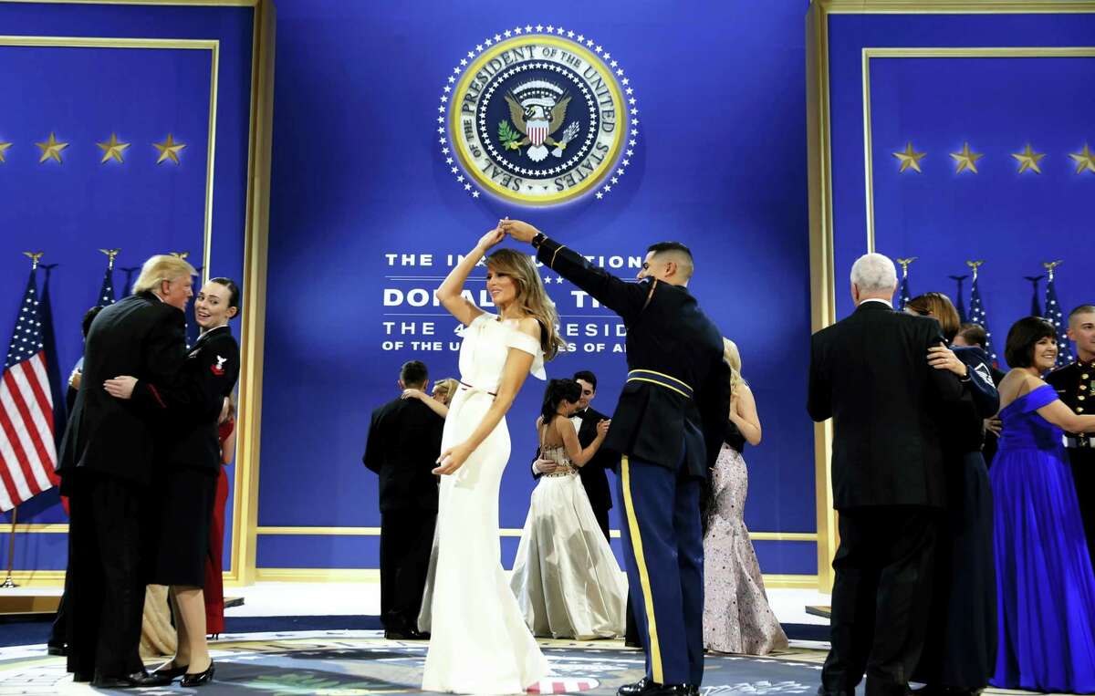 President Donald Trump, left, dances with Navy Petty Officer 2nd Class Catherine Cartmell as first lady Melania Trump is spun by Army Staff Sgt. Jose A. Medina during a dance at The Salute To Our Armed Services Inaugural Ball in Washington, Friday, Jan. 20, 2017.