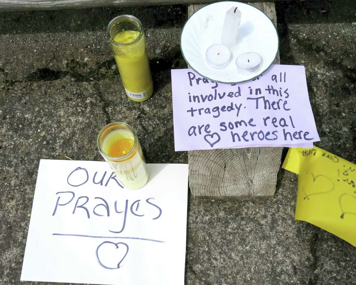 Well-wishing messages and candles for an injured employee are shown outside a grocery store in Estacada, Ore., Monday, May 15, 2017. Police say a man carrying what appeared to be a human head stabbed an employee at the grocery store.