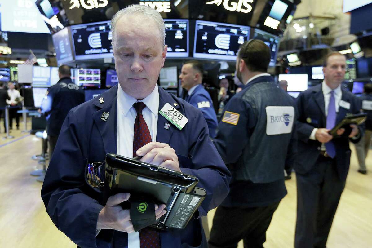 Trader James Riley, left, works on the floor of the New York Stock Exchange Tuesday.
