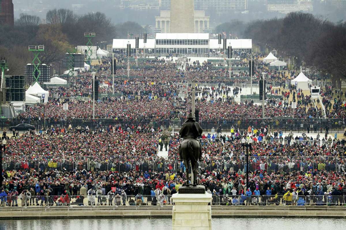 People stand on the National Mall to listen to the 58th Presidential Inauguration for President Donald Trump at the U.S. Capitol in Washington, Friday, Jan. 20, 2017. (AP Photo/Patrick Semansky)