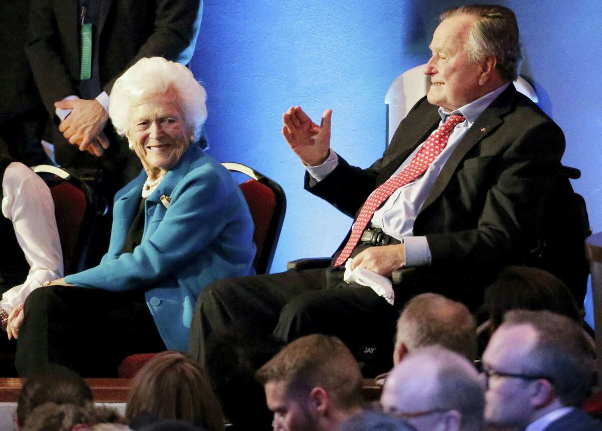 Former President George H. W. Bush, right, and his wife, Barbara, are greeted before a Republican presidential primary debate at The University of Houston in Houston in 2016.