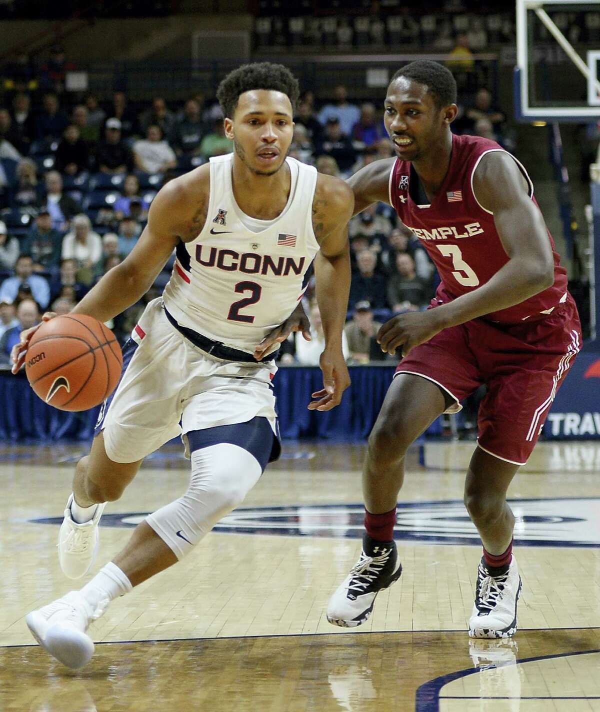 UConn’s Jalen Adams, left, dribbles around Temple’s Shizz Alston Jr. in the first half from action earlier this month. The Huskies play at SMU tonight.