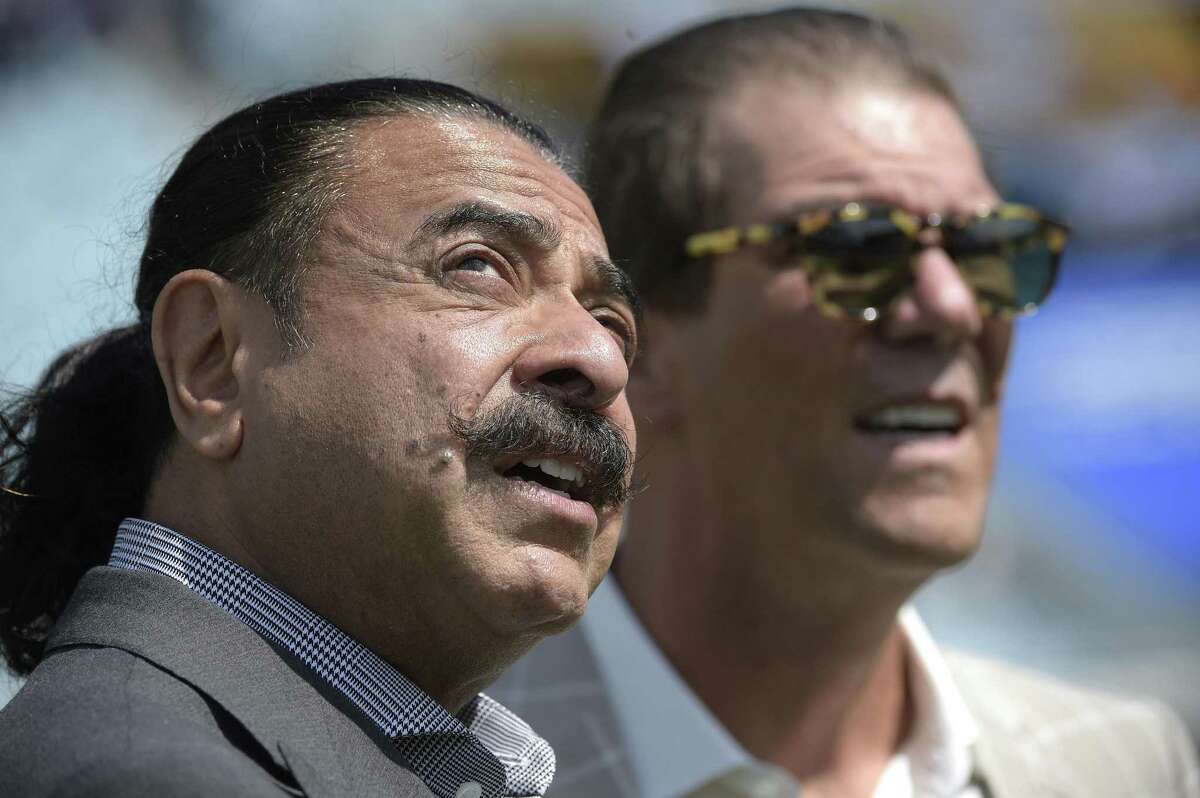 FILE - In a Sunday, Sept. 25, 2016 file photo, Jacksonville Jaguars owner Shad Khan, left, and Baltimore Ravens owner Stephen J. Bisciotti chat before an NFL football game in Jacksonville, Fla. Khan set the tone for the Jaguars season, saying a winning record was “everybody’s reasonable expectation, ” but the Jaguars (2-5) are among the NFL’s biggest disappointments. (AP Photo/Phelan M. Ebenhack, File)