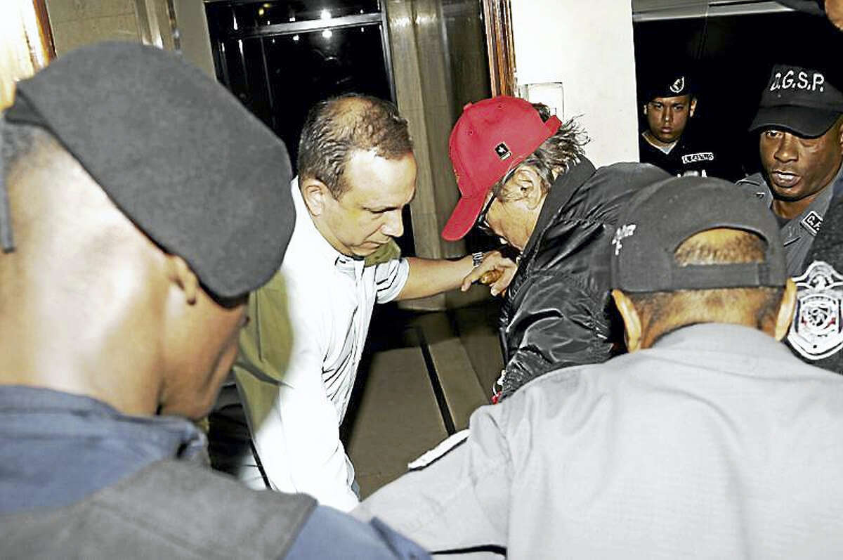 In this Jan. 28, 2017, file photo, Panamanian ex-dictator Manuel Antonio Noriega, wearing a red baseball cap, arrives after being placed under house arrest for three months in Panama City. Noriega has been hospitalized to undergo surgery to remove a benign tumor from his brain. Thays Noriega, one of his daughters, said surgery was scheduled for Tuesday, March 6.