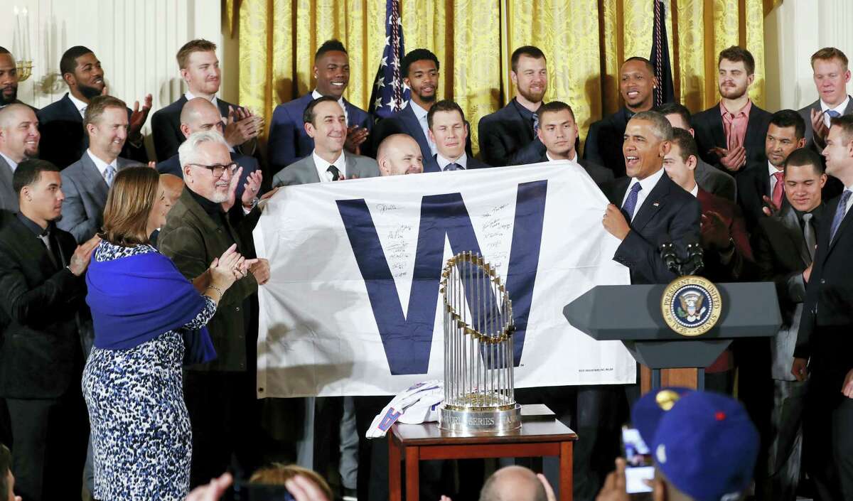 President Barack Obama holds up a ‘W’ flag signed by the Cubs during a ceremony in the East Room of the White House in Washington on Monday.