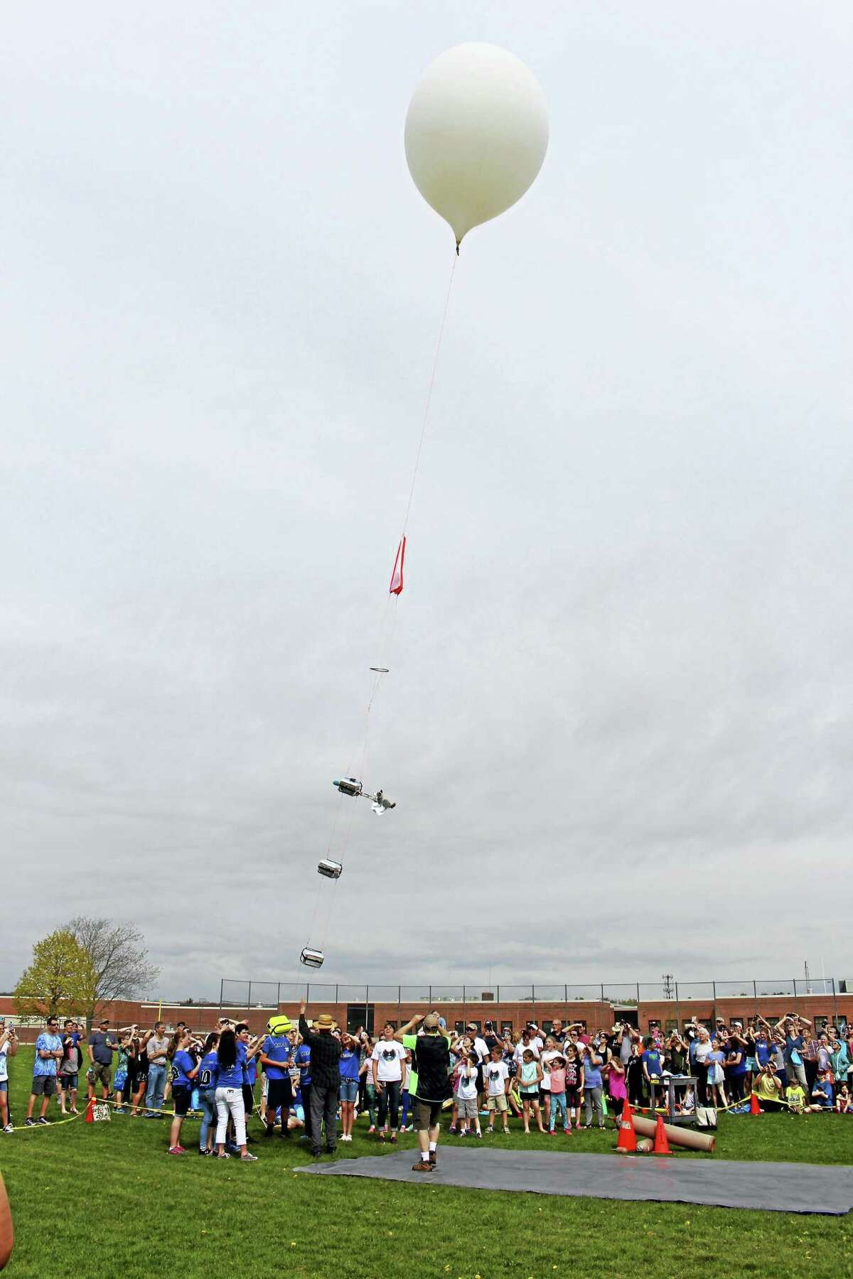 A crowd watches the StratoStar weather balloon launch from the Lewis Mills High School campus in Burlington. The event was part of a science-focused day of activities for students and parents.