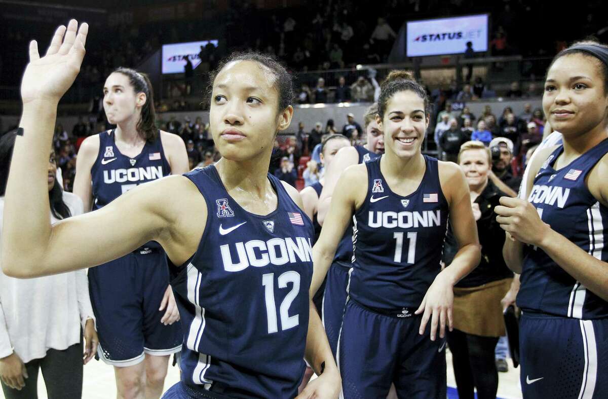 UConn’s Saniya Chong (12) and her teammates wave to fans after beating SMU Saturday in Dallas for the Huskies’ record 91st straight win.