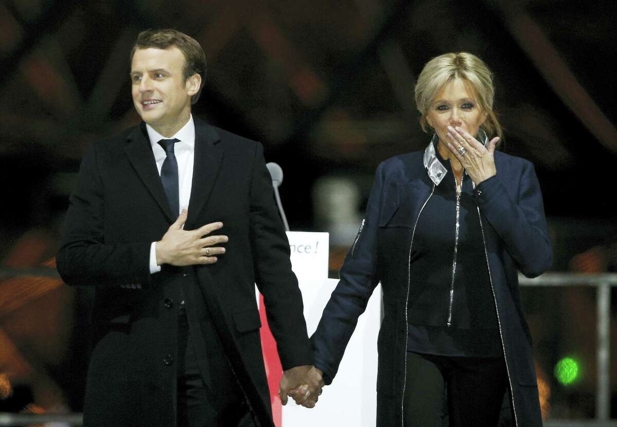 French President-elect Emmanuel Macron holds hands with his wife Brigitte during a victory celebration outside the Louvre museum in Paris, France. Speaking to thousands of supporters from the Louvre Museum’s courtyard, Macron said that France is facing an “immense task” to rebuild European unity, fix the economy and ensure security against extremist threats.