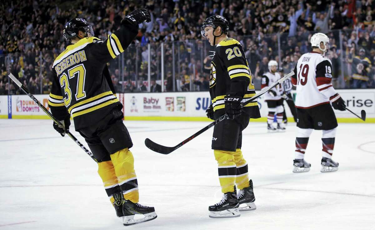 Boston Bruins center Riley Nash (20) celebrates after his short-handed goal off Arizona Coyotes goalie Mike Smith during the second period of an NHL hockey game in Boston, Tuesday, Feb. 28, 2017. At left is Bruins center Patrice Bergeron. (AP Photo/Charles Krupa)