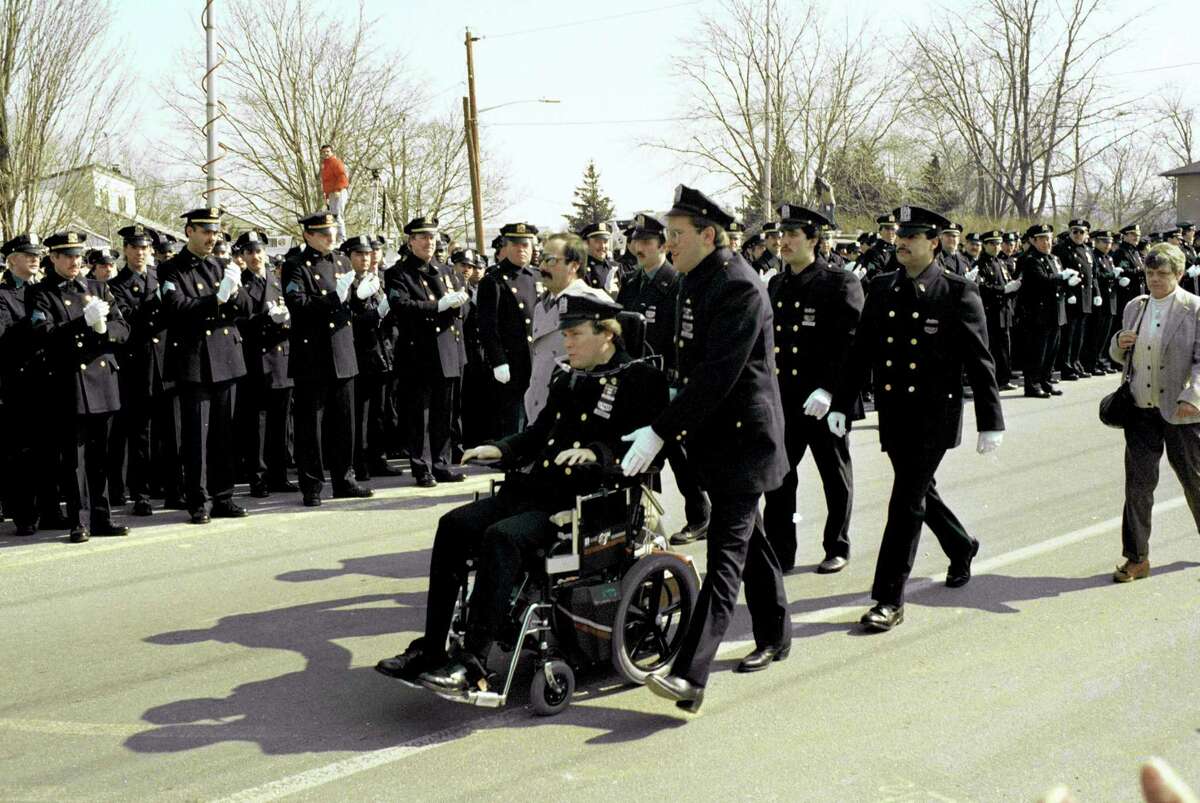 In 1988, paralyzed police officer Steven McDonald receives applause from members of the New York City Police Department as he arrives for funeral services at Seaford, N.Y., for slain officer Edward Byrne. McDonald, who was paralyzed by a bullet and became an international voice for peace after he publicly forgave the gunman, died Tuesday, Jan 10, 2017 at the age of 59.