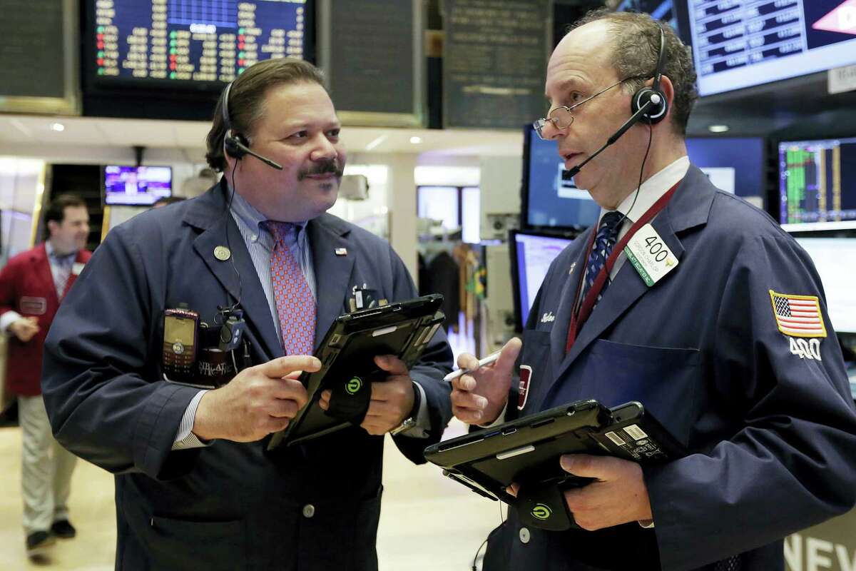 Traders John Santiago, left, and Gordon Charlop confer on the floor of the New York Stock Exchange, Monday. Technology and consumer-focused stocks are leading indexes slightly higher in early trading as investors return from a long holiday weekend.