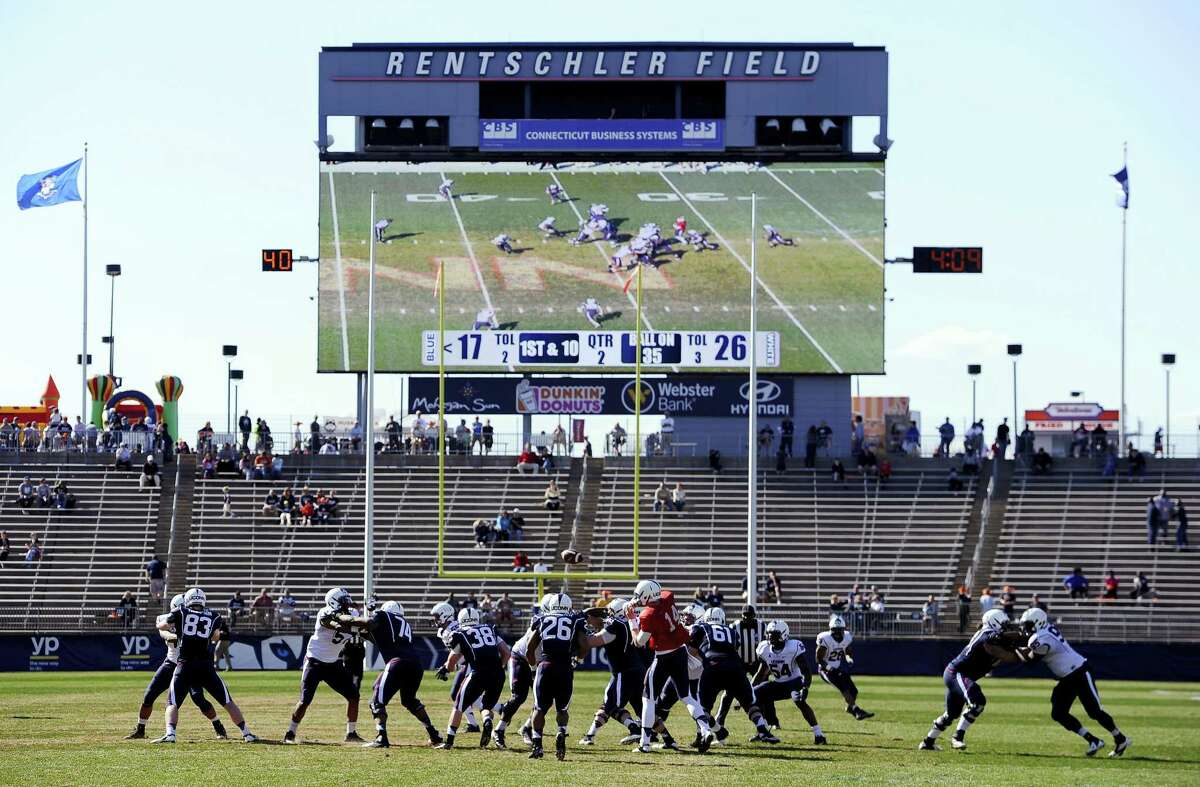 In this April 12, 2014 photo, Connecticut players run a play during the first half of UConn’s Blue-White spring NCAA college football game at Rentschler Field, in East Hartford, Conn. UConn is moving forward with plans to build new athletic facilities for its soccer, baseball and softball teams. The school’s board of trustees is expected to vote Wednesday, Feb. 22, 2017, to spend the first $4.75 million dollars to design the school’s “Athletic District,” where the fields will be located.