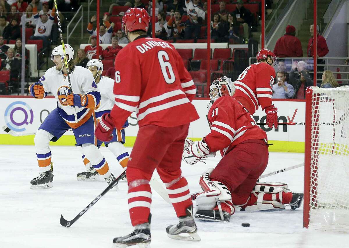 New York Islanders’ Scott Mayfield, left, reacts after scoring against Carolina Hurricanes goalie Eddie Lack (31), of Sweden, as Hurricanes’ Klas Dahlbeck (6), of Sweden, watches during the first period of an NHL hockey game in Raleigh, N.C. on April 6, 2017.