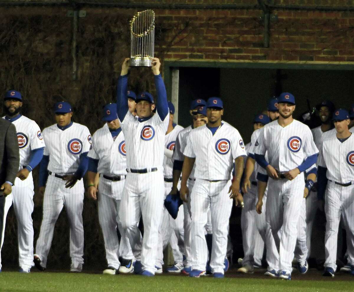 Chicago Cubs first baseman Anthony Rizzo (44) carries the 2016 World Series Championship trophy before a baseball game between the Chicago Cubs and the Los Angeles Dodgers on home opening day April 10, 2017 in Chicago.