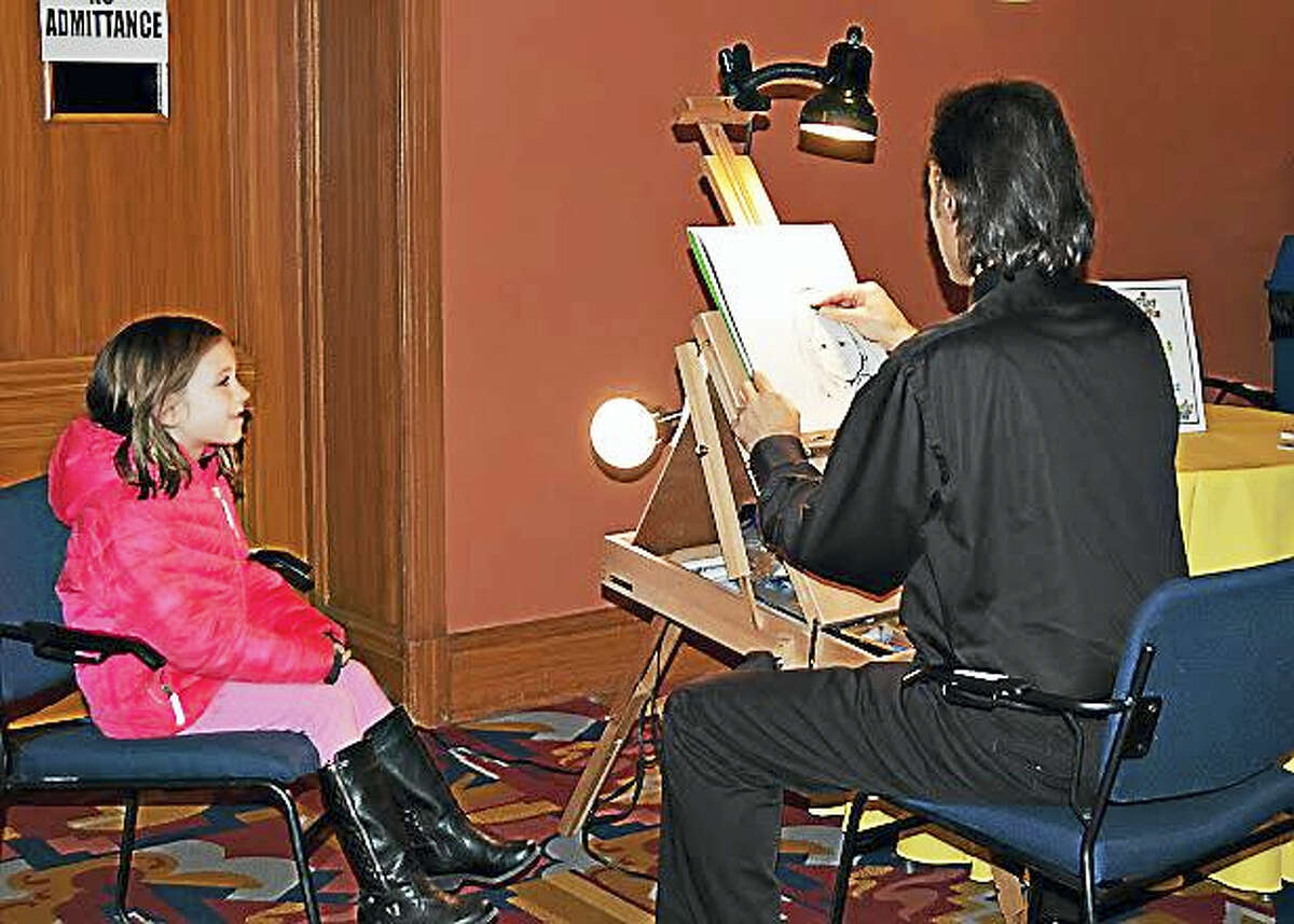 Caricature artist Bill Hernandez creates art for a young participant at last year’s KidsPlay museum event.