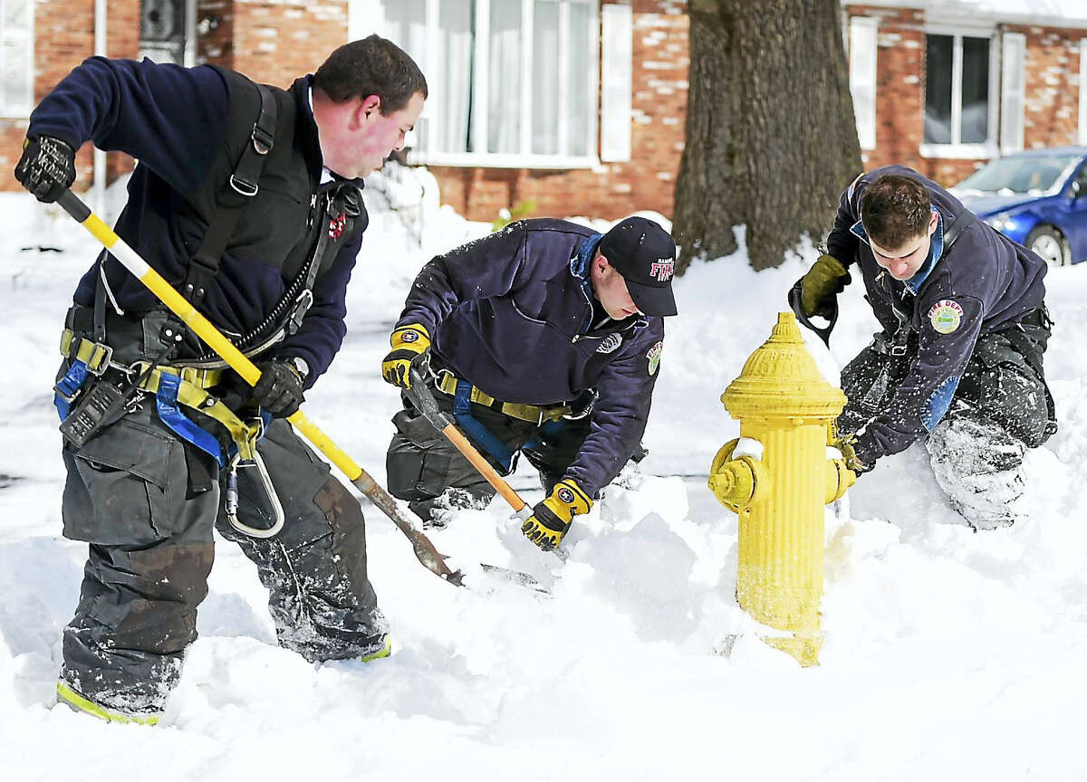 Peter Hvizdak — New Haven Register Hamden Fire Captain Adam Barletta with Hamden firefighters Cal Brennan and John Coughlin, left to right, dig out a fire hydrant on Mill Rock Road in Friday, February 10, 2017.