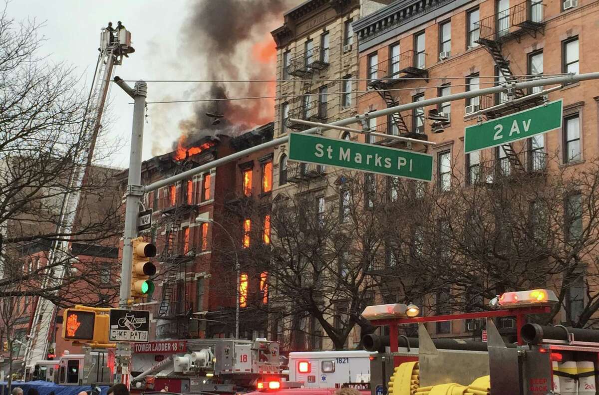 New York City firefighters work the scene of a large fire and a partial building collapse in the East Village neighborhood of New York Thursday.