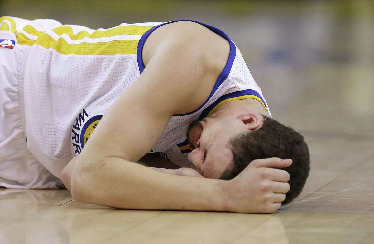 Golden State Warriors guard Klay Thompson reacts Wednesday after taking a knee to his head from Houston Rockets forward Trevor Ariza.