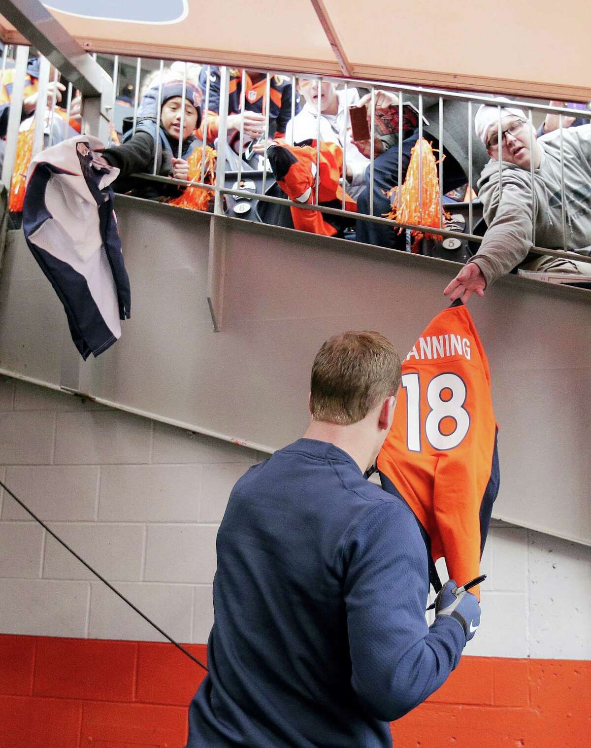 Peyton Manning signs autographs before the NFL football AFC Championship game between the Denver Broncos and the New England Patriots, Sunday, Jan. 24, 2016, in Denver. (AP Photo/Charlie Riedel)