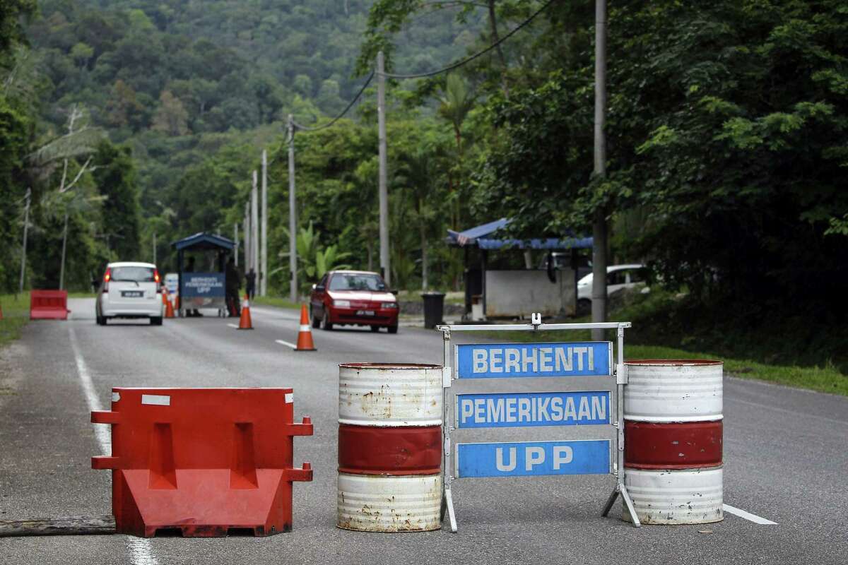 A check point is seen at the entry point to Malaysia - Thailand border in Wang Kelian, Malaysia on May 24, 2015. Malaysian authorities said Sunday that they have discovered graves in more than a dozen abandoned camps used by human traffickers on the border with Thailand, where Rohingya Muslims fleeing Myanmar have been held. The blue signs read, from top, “Stop,” “Inspection,” and “UPP (Anti-Smuggling Unit).”