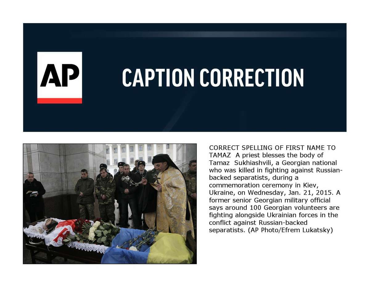 CORRECT SPELLING OF FIRST NAME TO TAMAZ A priest blesses the body of Tamaz Sukhiashvili, a Georgian national who was killed in fighting against Russian-backed separatists, during a commemoration ceremony in Kiev, Ukraine, on Wednesday, Jan. 21, 2015. A former senior Georgian military official says around 100 Georgian volunteers are fighting alongside Ukrainian forces in the conflict against Russian-backed separatists. (AP Photo/Efrem Lukatsky)