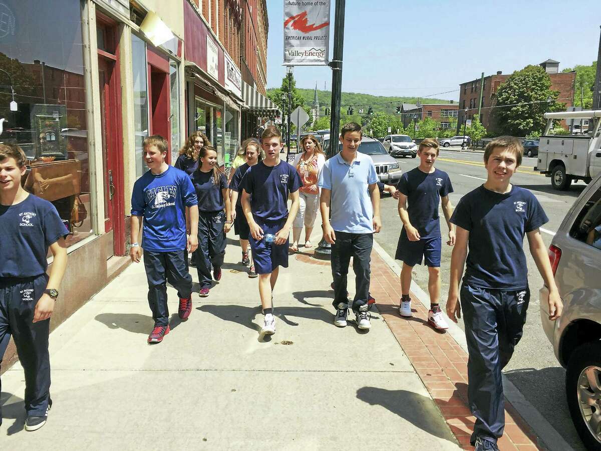 PHOTO BY BEN LAMBERT Eighth-grade students from St. Anthony School walk through downtown Winsted on their way to the American Museum of Tort Law.