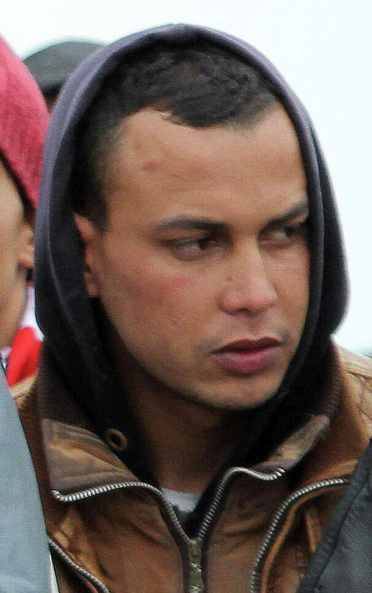 In this photo taken on Feb. 17 2015, Abdelmajid Touil, right, waits to be disembarked in Porto Empedocle, Sicily, Italy. Touil Abdelmajid was arrested Tuesday evening at the home of his mother in Gaggiano, near Milan. Italian police have arrested the Moroccan man on a Tunisian arrest warrant accusing him of helping organize and execute the March 18 attack on Tunisia's Bardo museum that left 22 people dead, authorities said. (Pasquale Claudio Montana Lampo/ANSA via AP Photo) - ITALY OUT