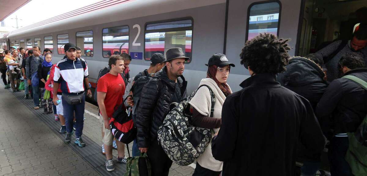 Migrants and refugees board a train from Vienna to Salzburg at the Westbahnhof train station in Vienna Saturday.
