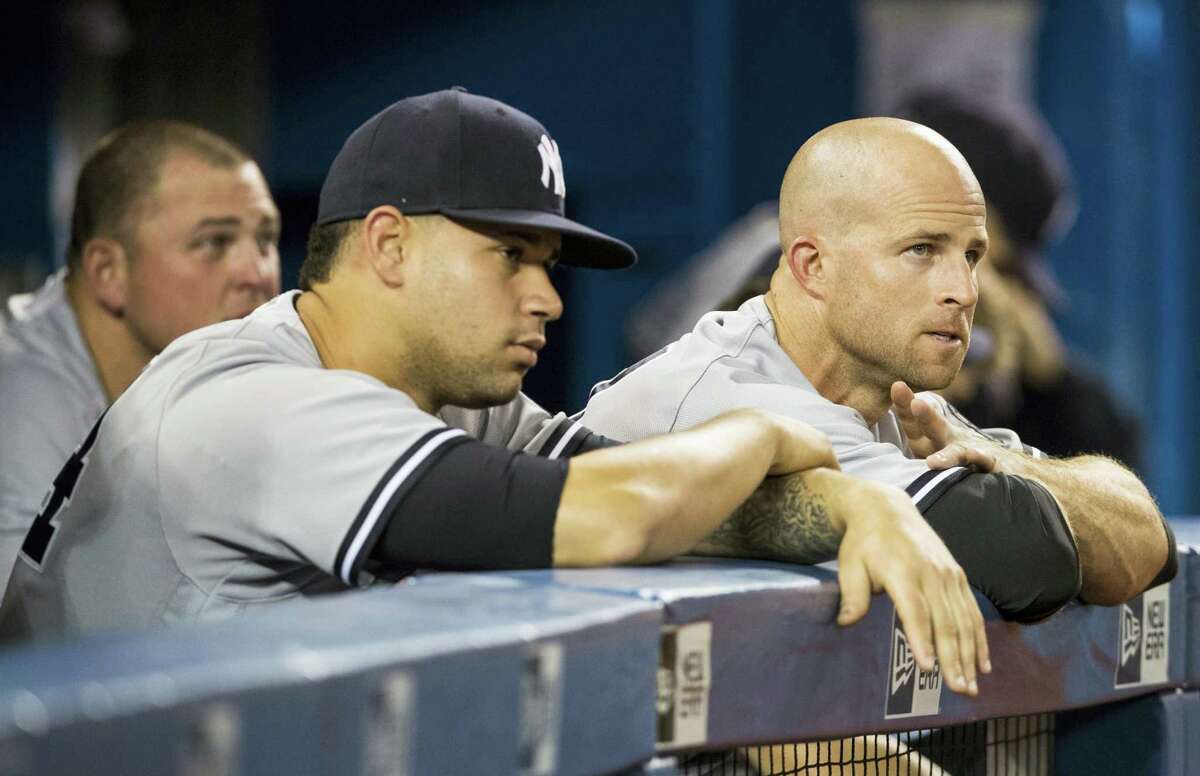 Brett Gardner, right, and Gary Sanchez, front left, watch the last few outs of Friday’s game.
