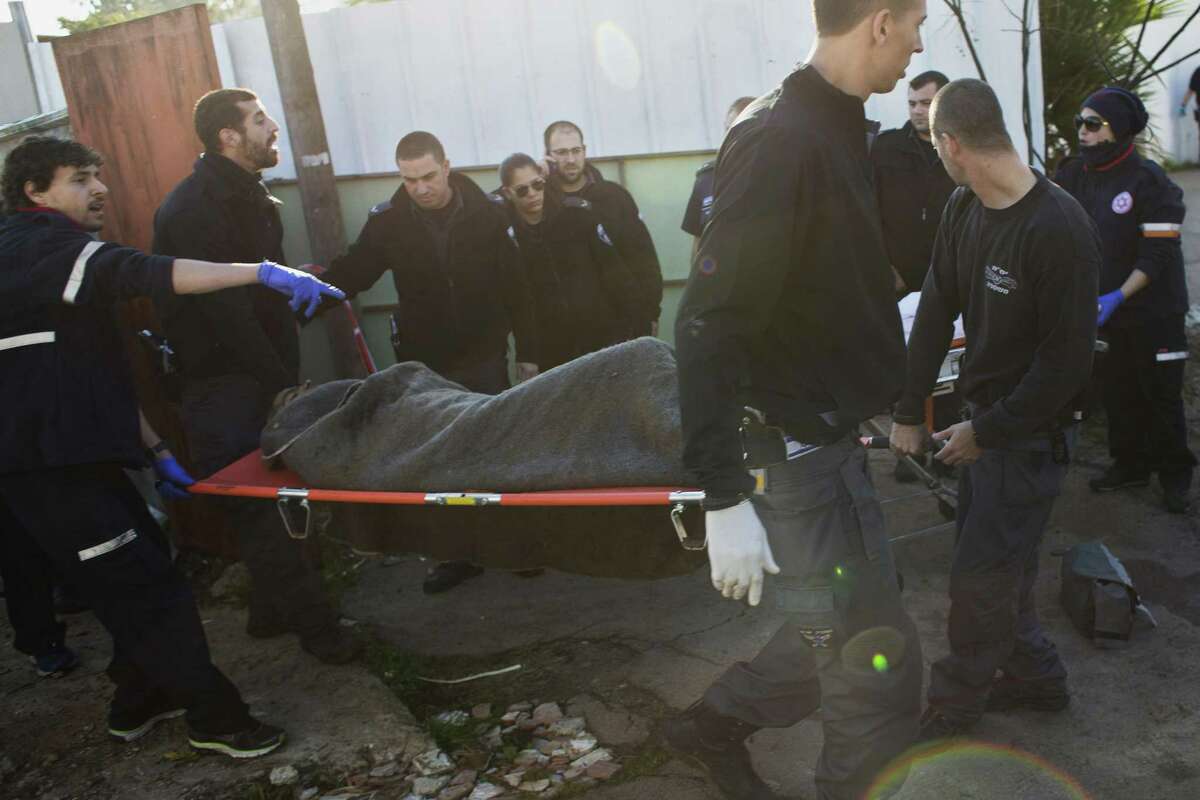 Israeli police officers and medics carry a Palestinian suspected of stabbing people from an area near the attacking site in Tel Aviv, Israel, Wednesday, Jan. 21, 2015. A Palestinian man stabbed at least 11 people on and near a bus in central Tel Aviv on Wednesday, seriously wounding three of them before he was shot and arrested by Israeli police. (AP Photo/Oren Ziv)