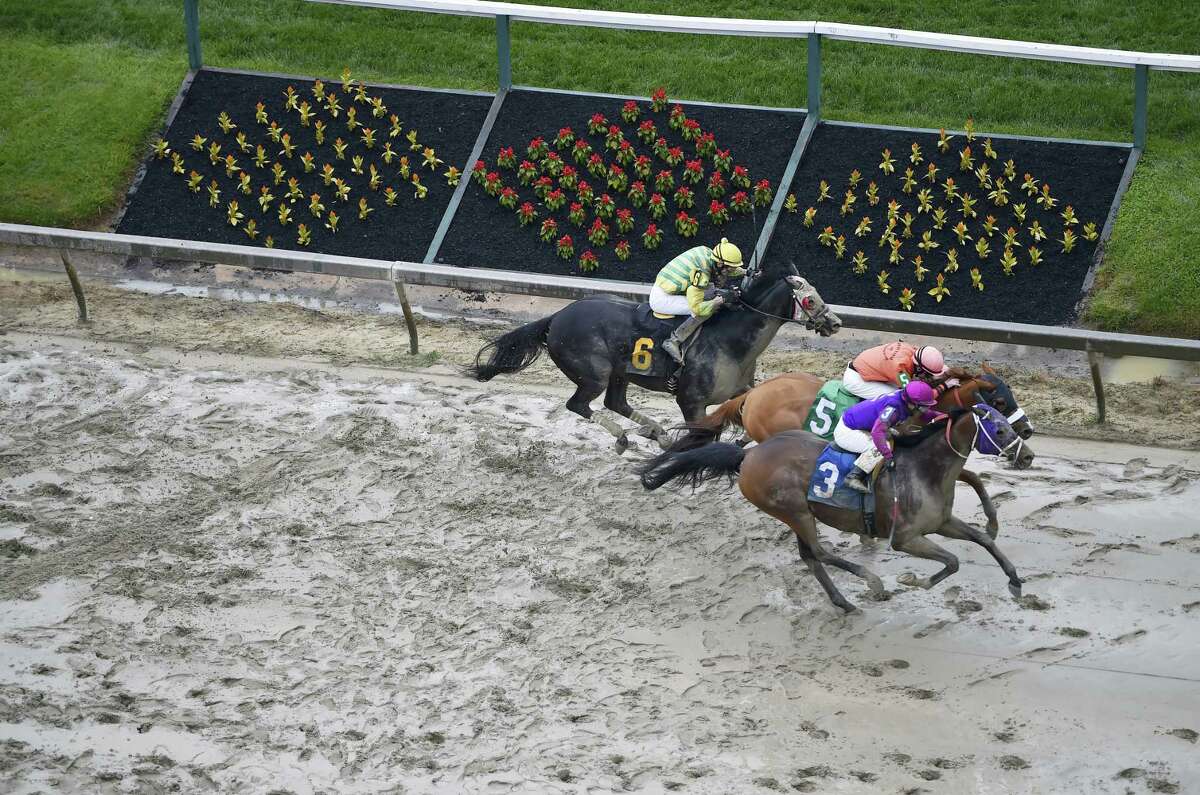 Homeboykris (3), ridden by Horacio Karamanos, wins the first race of the day on a muddy track ahead of the 141st Preakness Stakes on Saturday. After the race, Homeboykris collapsed and died after having his picture taken in the winner’s circle.