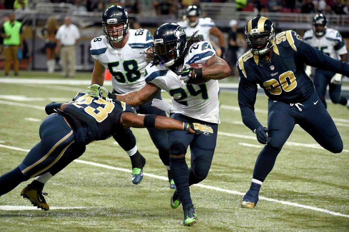 Seattle Seahawks running back Marshawn Lynch (24) runs with the ball as Rams free safety Rodney McLeod (23) and defensive tackle Michael Brockers (90) defend during Sunday’s game in St. Louis.