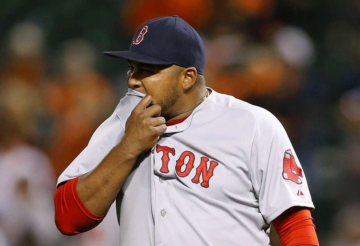 Red Sox relief pitcher Jean Machi wipes sweat from his face after the Orioles’ Chris Davis scored on Adam Jones’ double in the seventh inning on Monday.