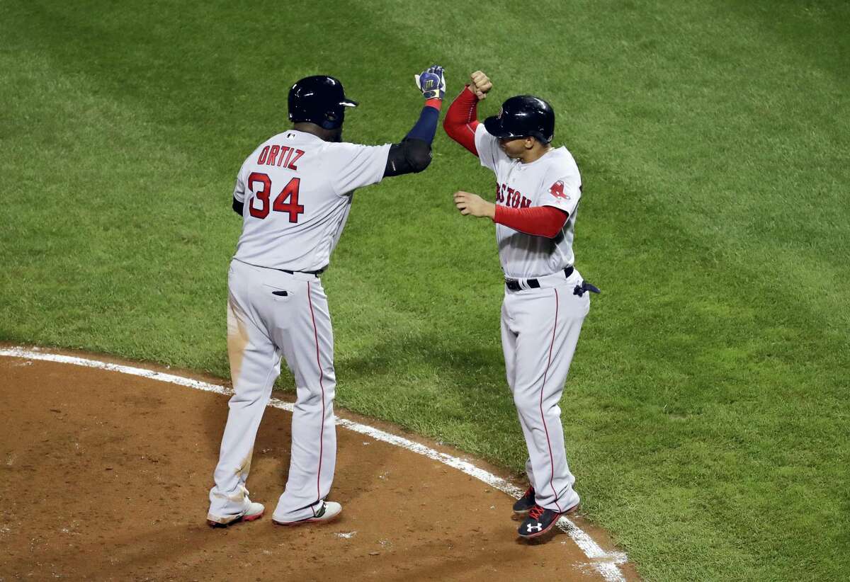 Boston’s David Ortiz, left, celebrates with teammate Marco Hernandez after driving him in on a three-run home run in the seventh inning against the Baltimore Orioles.