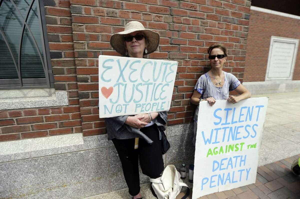 Demonstrators hold signs against the death penalty outside federal court in Boston during the penalty phase in Dzhokhar Tsarnaev’s trial Monday, May 11, 2015. Tsarnaev was convicted of the Boston Marathon bombings that killed three and injured 260 people in April 2013.