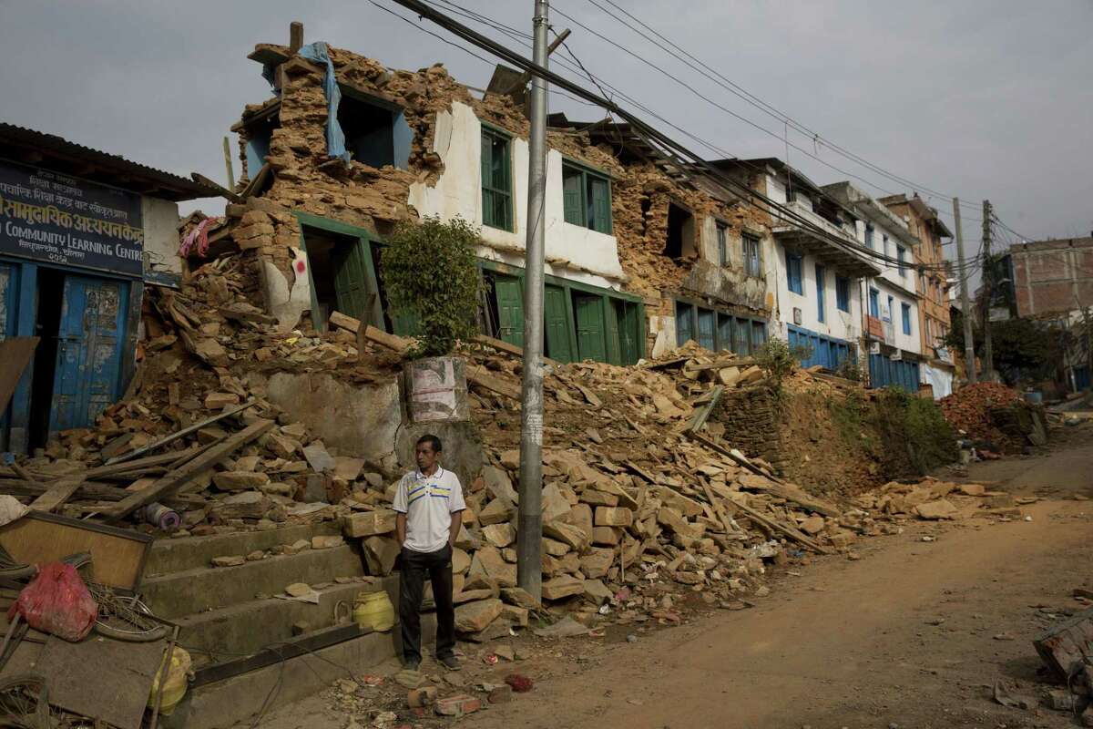 A man inspects an area that was severely affected in the May 12 earthquake stands tilted in Chautara, Nepal, Wednesday, May 13, 2015. Thousands of fear-stricken people spent the night outdoors after a new earthquake killed dozens of people and spread more misery in Nepal, which is still reeling from a devastating quake that killed thousands nearly three weeks ago. (AP Photo/Bernat Amangue)