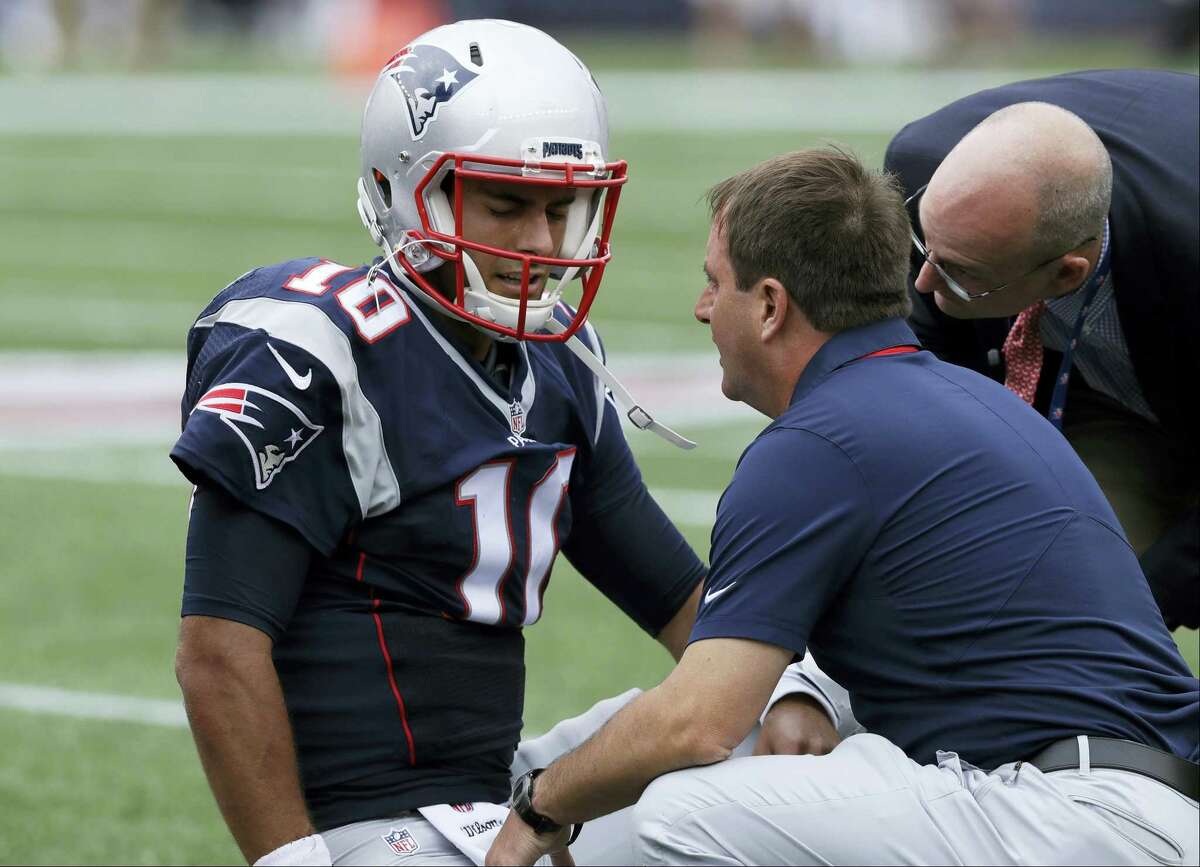 New England Patriots quarterback Jimmy Garoppolo receives attention after an injury during the first half of an NFL football game against the Miami Dolphins on Sept. 18, 2016 in Foxborough, Mass.