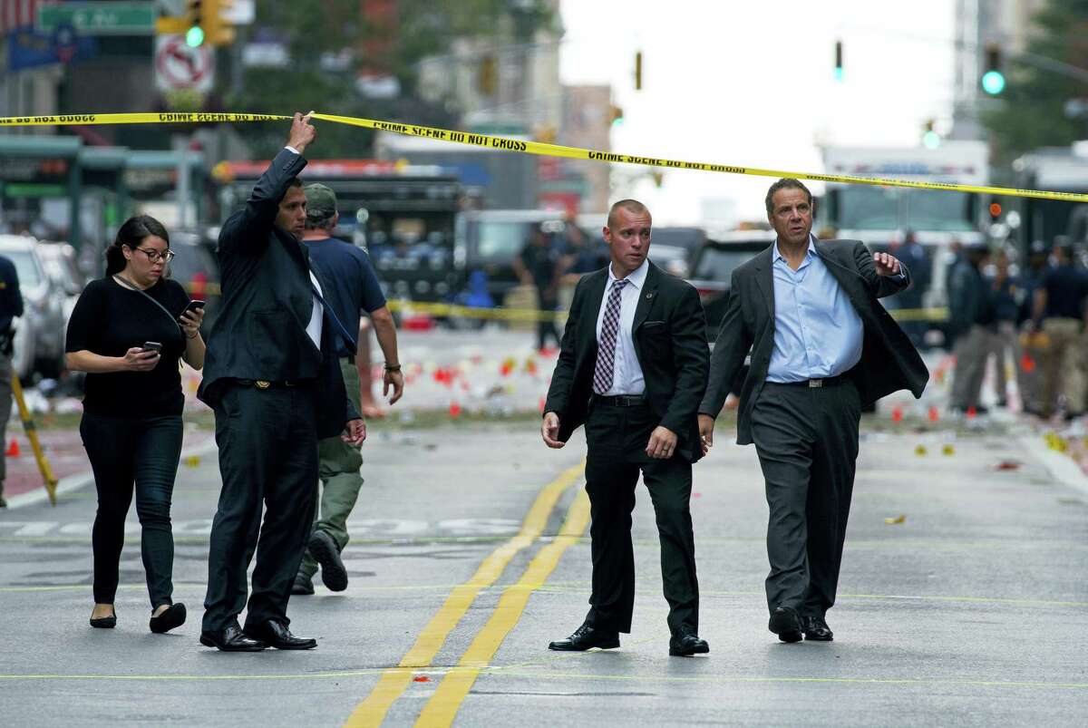 New York Gov. Andrew Cuomo, right, walks from the scene of an explosion in Manhattan’s Chelsea neighborhood in New York on Sept. 18, 2016, after an incident that injured passers-by Saturday night.