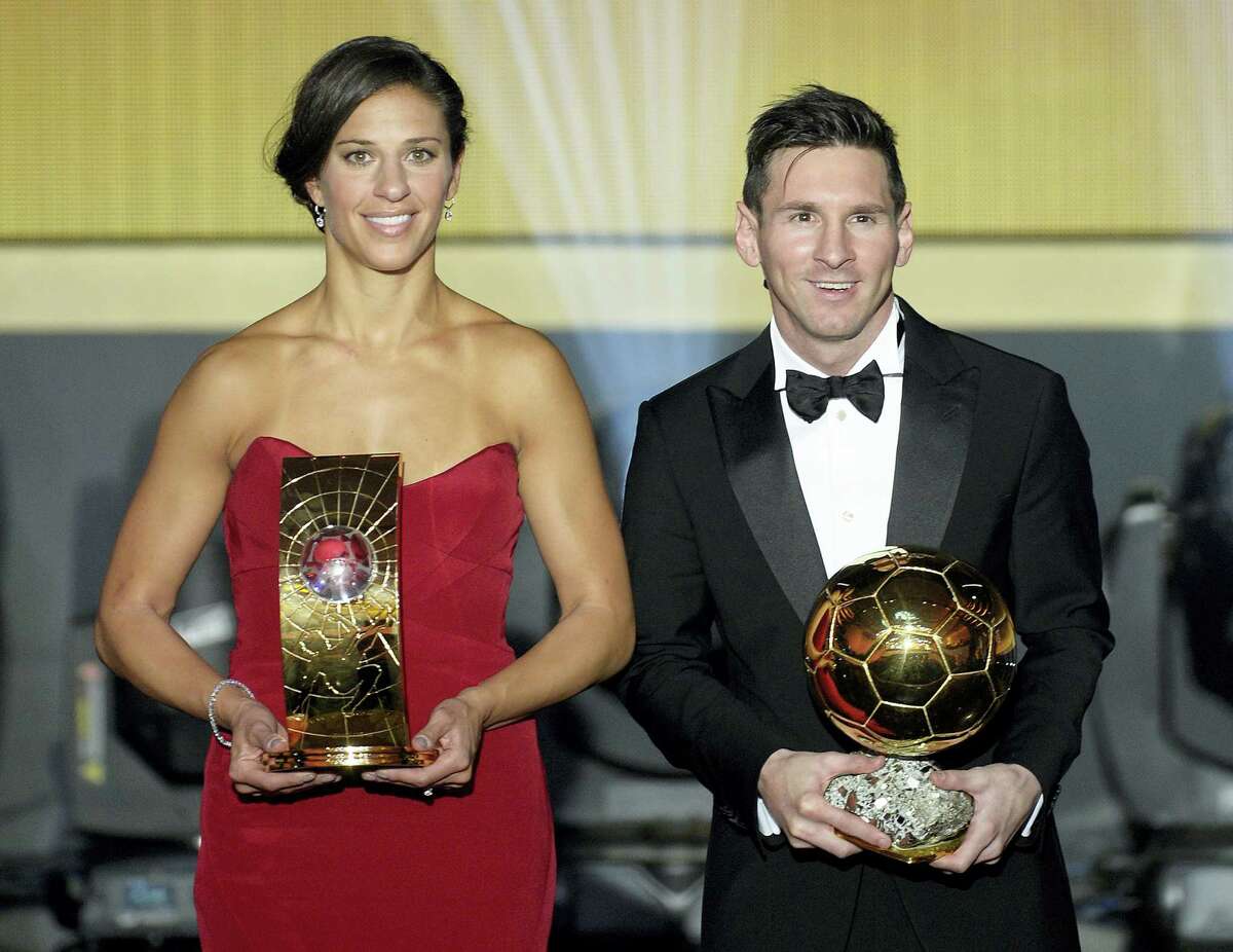 Carli Lloyd, left, and Lionel Messi pose with their trophies after winning the FIFA soccer player of the year awards on Monday.