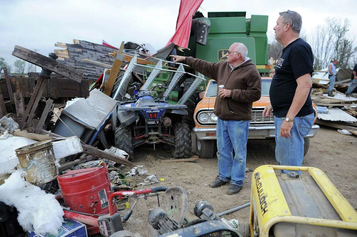 Mike Fechner, left, surveys damage to his property with Tim Asche, of American Family Insurance, on May 10, 2015 near Delmont, S.D.