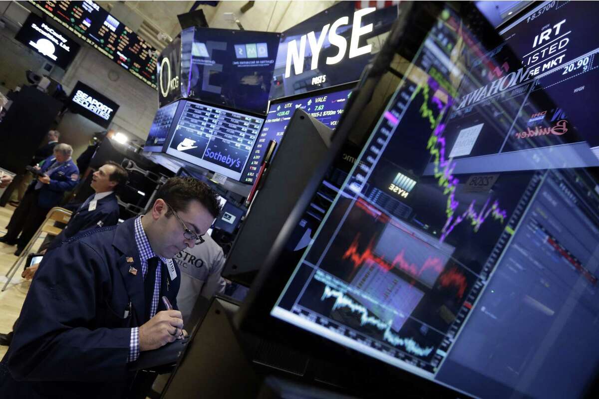 Trader Philip Carone, left, works on the floor of the New York Stock Exchange Monday.