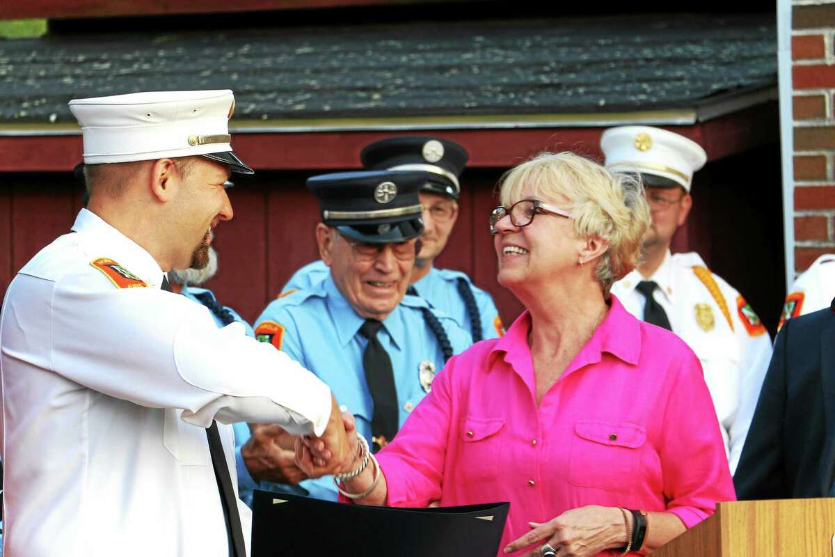 Norfolk First Selectman Susan M. Dyer, who also read a General Assembly citation marking the event, congratulates Norfolk Volunteer Fire Chief Matthew Ludwig.