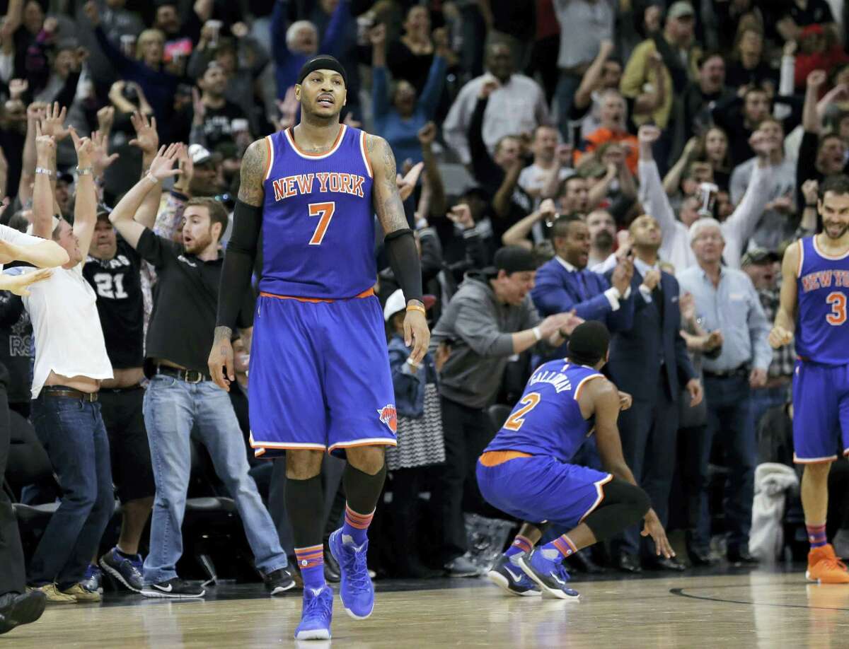 New York Knicks forward Carmelo Anthony (7) walks off the court after teammate Jose Calderon (3) missed a last-second shoot against the San Antonio Spurs during the second half of an NBA basketball game Friday, Jan. 8, 2016, in San Antonio. San Antonio won 100-99. (AP Photo/Eric Gay)