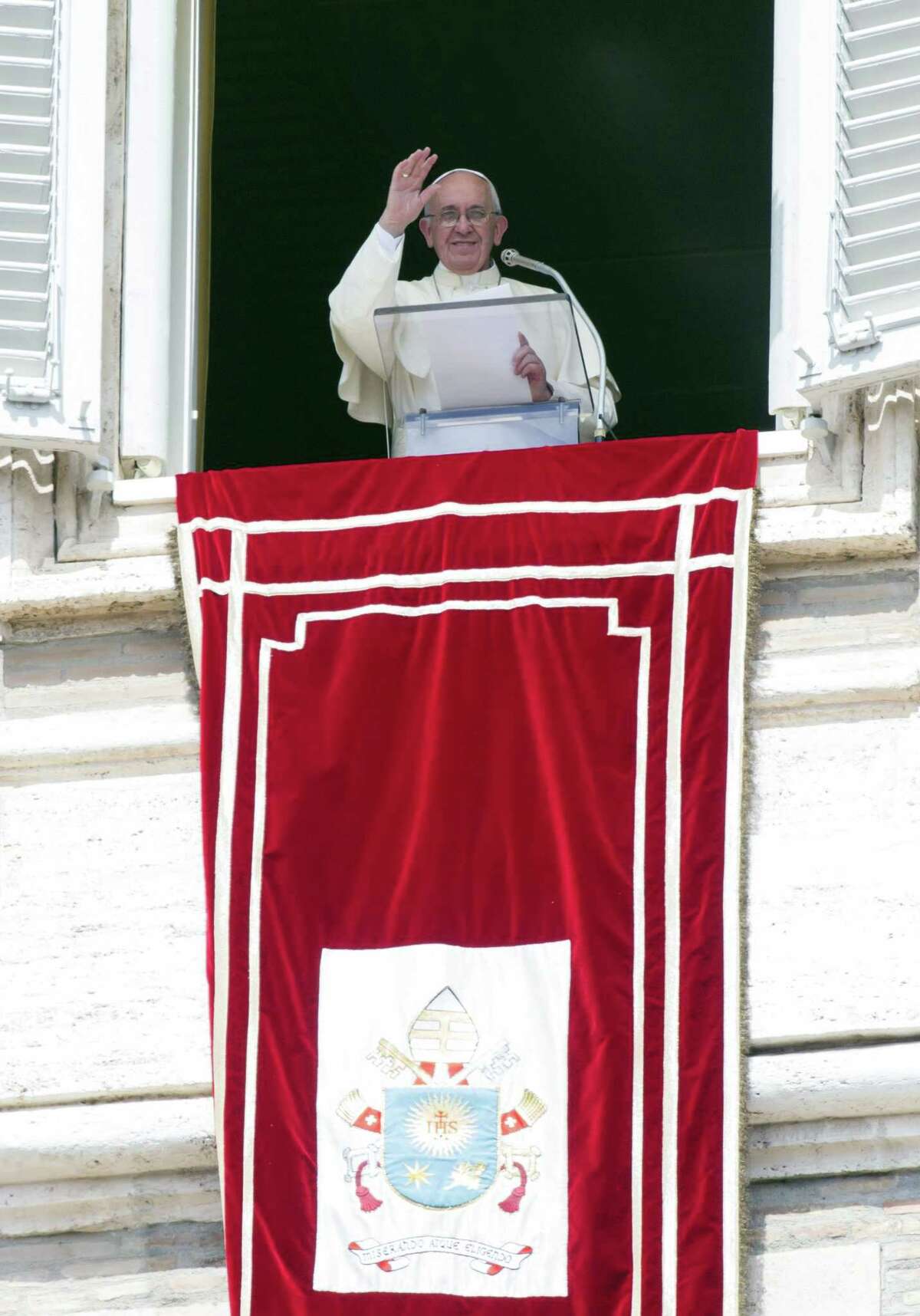 Pope Francis delivers his blessing during the Angelus noon prayer from his studio window overlooking St. Peter’s Square at the Vatican ib Sept. 6, 2015. The Vatican will shelter two families of refugees “who are fleeing death” from war or hunger, Pope Francis announced Sunday as he called on Catholic parishes, convents and monasteries across Europe to do the same.