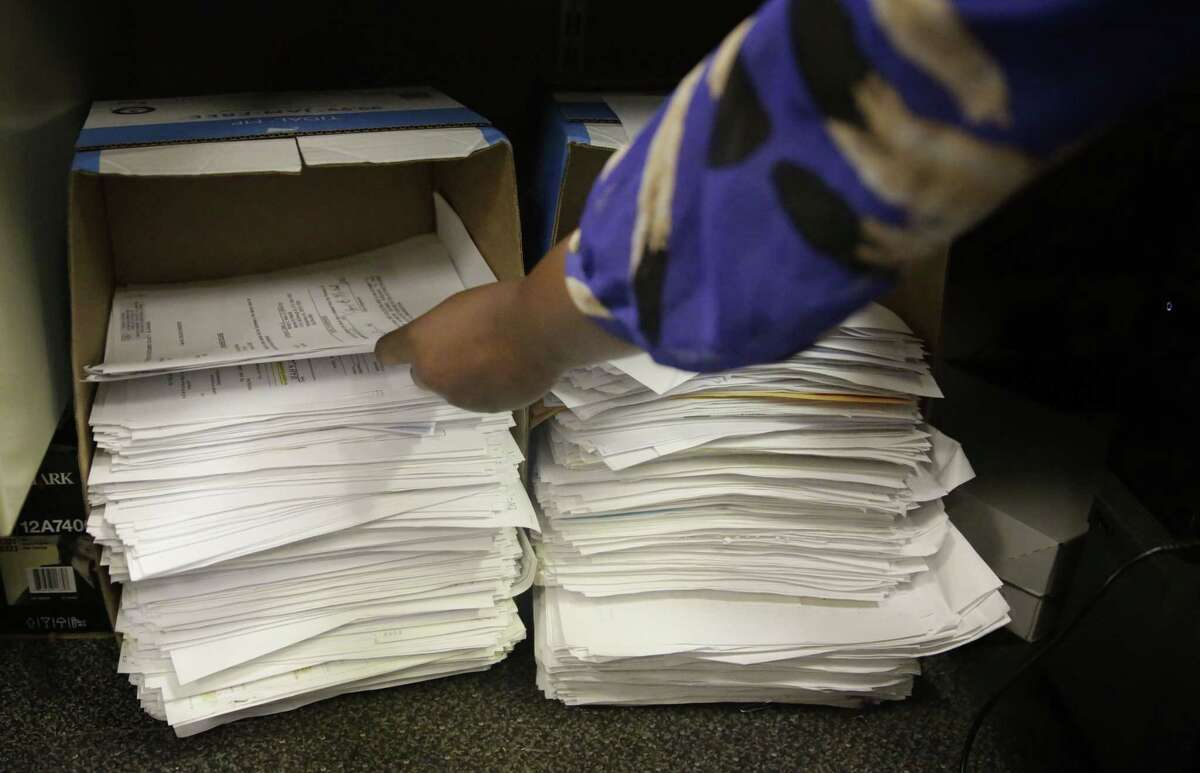 Stacks of documents gather under court specialist Trameka Daniels’ desk daily at the Alabama Circuit Court Clerk Criminal office on May 7, 2015 in Montgomery, Ala. A trend is emerging among states like Alabama showing large budget gaps.